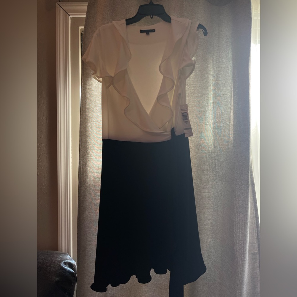 Black and white V- neck dress with ruffled neck line and slit by leg